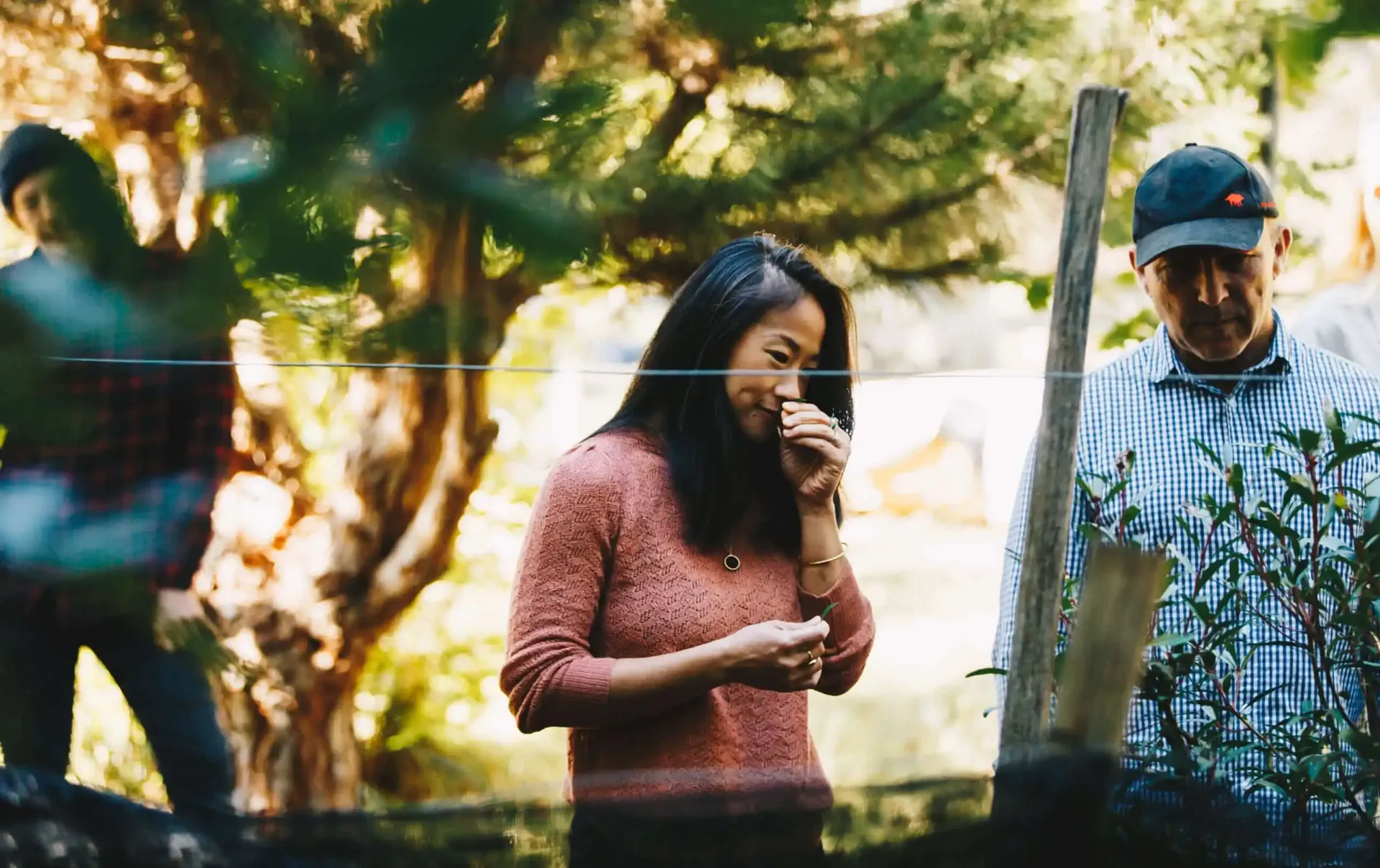 A woman and 2 men in a farm field